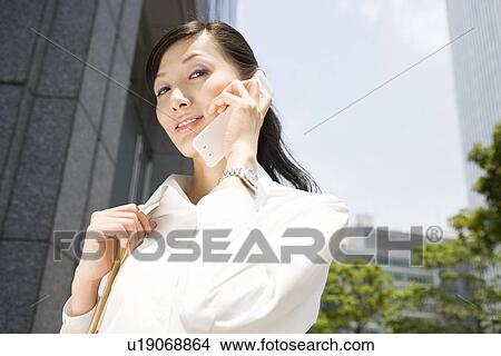 Young woman using mobile phone View Large Photo Image Picture - Young woman using mobile phone. Fotosearch