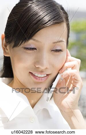 Young woman using mobile phone View Large Photo Image Stock Photo - Young woman using mobile phone. Fotosearch