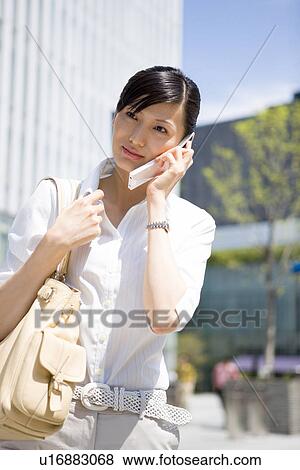 Young woman using mobile phone View Large Photo Image Stock Photo - Young woman using mobile phone. Fotosearch