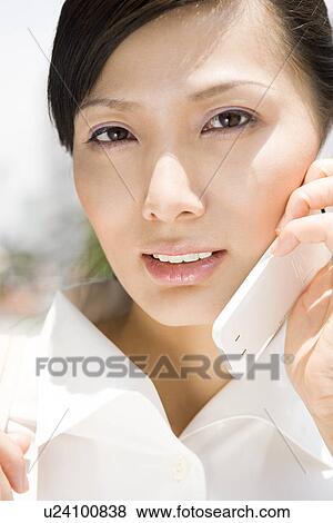 Stock Photo - Young woman using mobile phone. Fotosearch