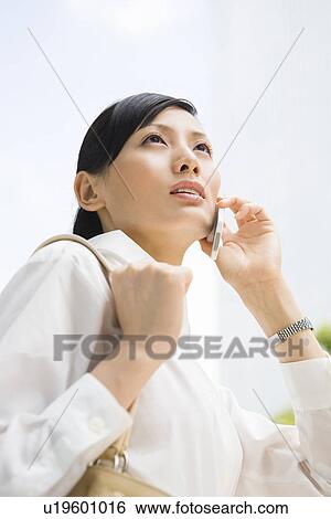 Stock Photograph - Young woman using mobile phone. Fotosearch