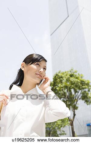 Stock Photography - Young woman using mobile phone. Fotosearch