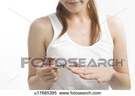 Stock Photography - Young woman cutting nails. Fotosearch
