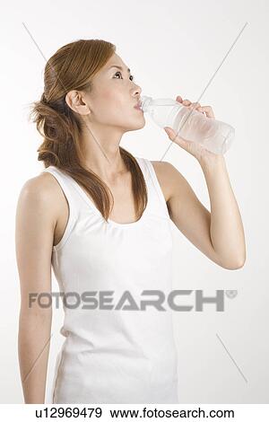 Stock Photo - Young woman drinking mineral water. Fotosearch