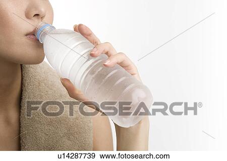 Stock Photo - Young woman drinking mineral water. Fotosearch