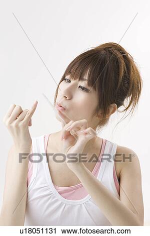 Stock Image - Young woman filing fingernails. Fotosearch