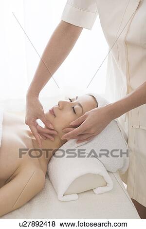 Stock Photo - Young woman having facial massage. Fotosearch
