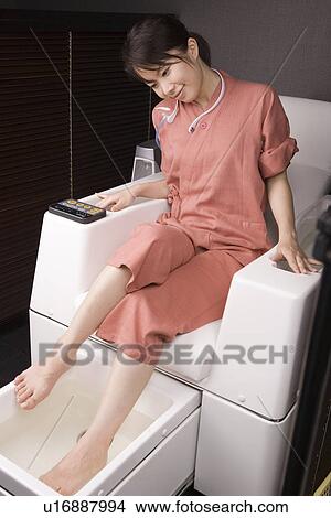 Picture - Young woman having foot bath. Fotosearch