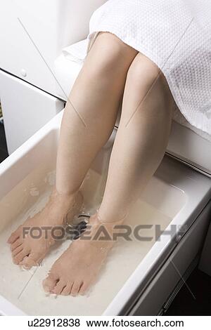 Stock Photo - Young woman having foot bath. Fotosearch