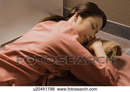 Stock Photo - Young woman lying at bedrock bath. Fotosearch