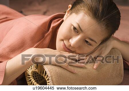 Stock Photography - Young woman lying at bedrock bath. Fotosearch