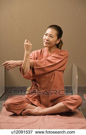 Stock Photo - Young woman stretching at bedrock bath. Fotosearch