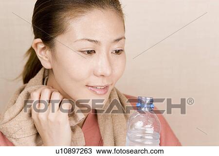 Young woman wiping face with towel View Large Photo Image Stock Image - Young woman wiping face with towel. Fotosearch