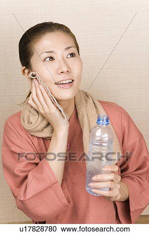 Young woman wiping face with towel View Large Photo Image Stock Image - Young woman wiping face with towel. Fotosearch