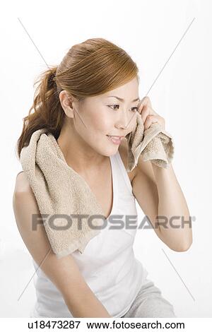 Stock Photo - Young woman wiping face with towel. Fotosearch