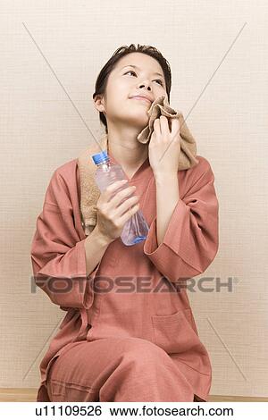 Young woman wiping face with towel View Large Photo Image Stock Photograph - Young woman wiping face with towel. Fotosearch