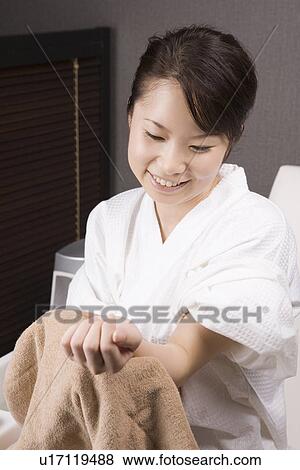 Stock Photo - Young woman wiping hand with towel. Fotosearch