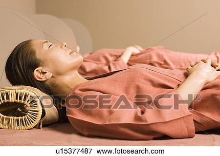 Stock Photo - Young women lying at bedrock bath. Fotosearch