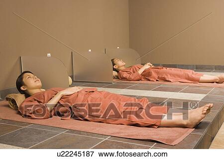 Young women lying at bedrock bath View Large Photo Image Stock Photo - Young women lying at bedrock bath. Fotosearch