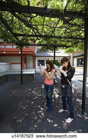 Two women reading fortune paper View Large Photo Image Stock Image - Two women reading fortune paper. Fotosearch