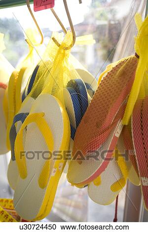 Stock Image - Flip-flops hanging in shop. Fotosearch