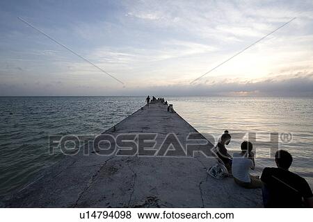Stock Photo - People sitting in pier. Fotosearch