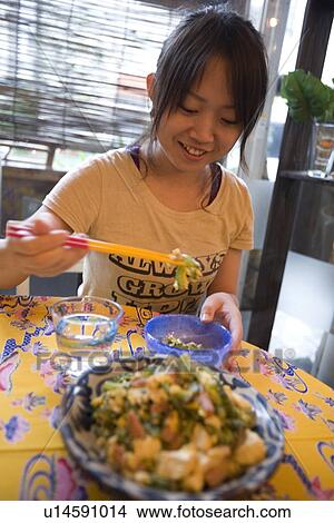 Yong woman eating fried bitter gourd View Large Photo Image Picture - Yong woman eating fried bitter gourd. Fotosearch