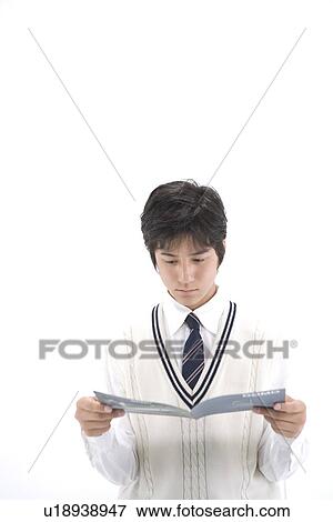 Stock Photo - Teenage boy reading brochure. Fotosearch
