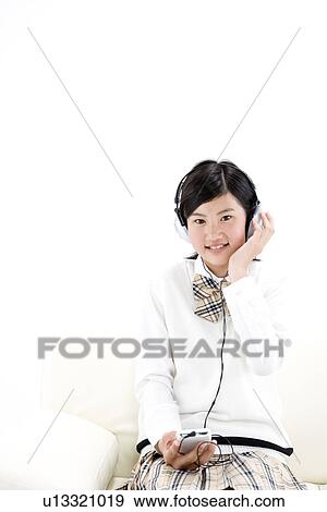 Stock Photo - Teenage girl listening to music. Fotosearch