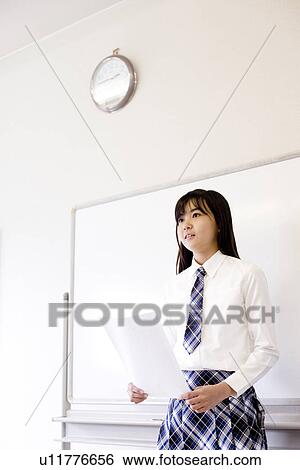 Stock Photograph - Teenage girl standing in front of white board. Fotosearch