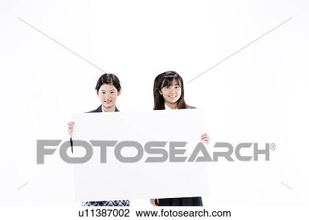 Stock Image - Two teenage girls holding blank message board. Fotosearch