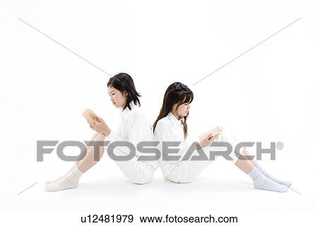 Stock Photo - Two teenage girls reading books. Fotosearch