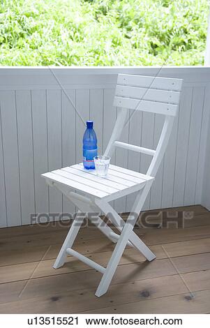 Stock Image - Mineral water and glass on chair. Fotosearch