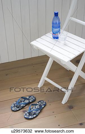Stock Image - Mineral water and glass on chair. Fotosearch