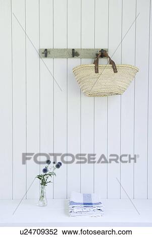 Stock Image - Straw bag hanging on wall. Fotosearch