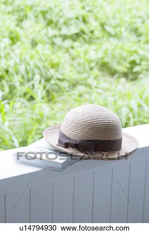 Stock Image - Straw hat and book. Fotosearch