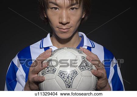 Picture - Portrait of soccer player holding ball. Fotosearch