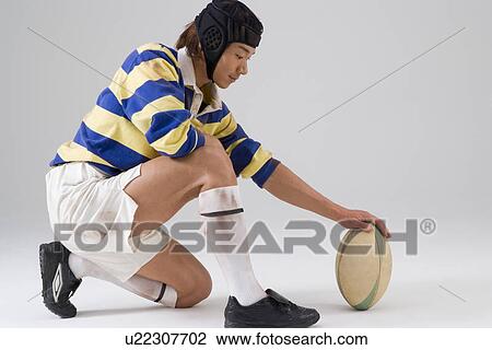 Stock Image - Rugby player placing ball. Fotosearch
