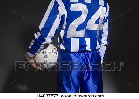 Stock Photo - Soccer player holding ball. Fotosearch