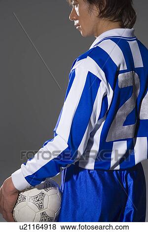Soccer player holding ball View Large Photo Image Stock Photo - Soccer player holding ball. Fotosearch