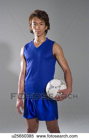 Stock Photography - Soccer player holding ball. Fotosearch