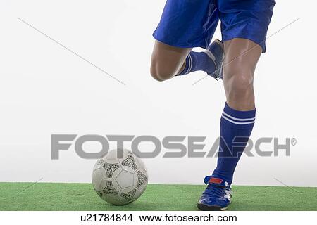 Soccer player kicking soccer ball View Large Photo Image Picture - Soccer player kicking soccer ball. Fotosearch