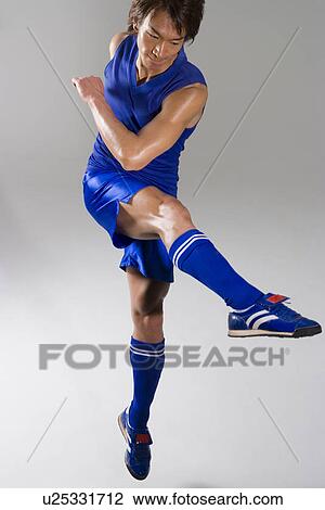 Soccer player kicking soccer ball View Large Photo Image Stock Image - Soccer player kicking soccer ball. Fotosearch