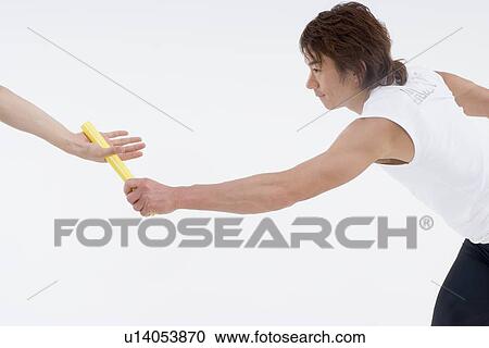 Stock Image - Young man giving relay baton. Fotosearch