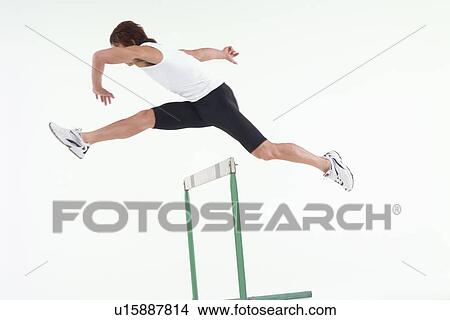 Young man jumping hurdle View Large Photo Image Picture - Young man jumping hurdle. Fotosearch