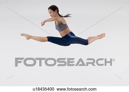 Stock Image - Young woman jumping. Fotosearch