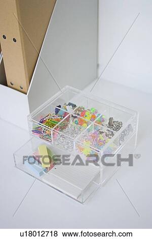 Stock Photo - Clips and pushpins in plastic box. Fotosearch