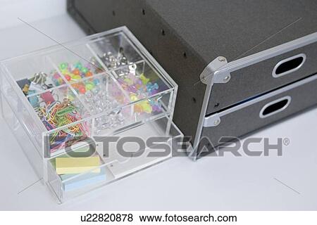 Stock Photo - Clips and pushpins in plastic box. Fotosearch