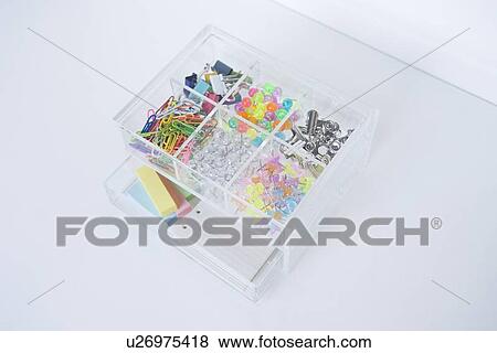 Stock Photo - Clips and pushpins in plastic box. Fotosearch