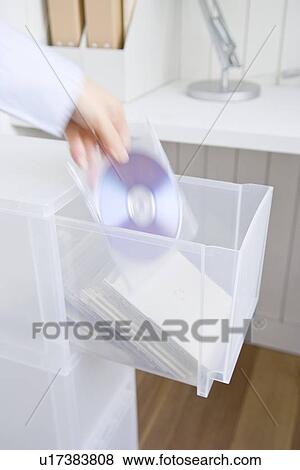Stock Photo - Woman picking CD from drawer. Fotosearch